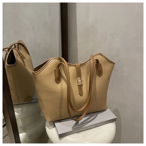 Close-up of khaki pebbled leather tote bag with elegant gold metal twist lock buckle
