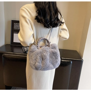 Détail d'un sac nuage en fausse fourrure grise avec poignée en cuir tressé pour l'hiver