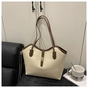 Detail of lychee pattern leather tote bag with brown straps and gold metal buckle