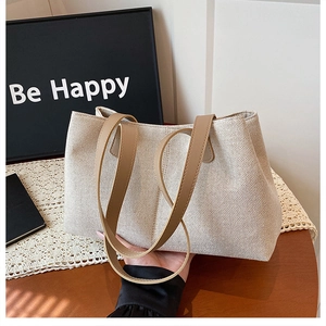 Close-up of durable cream canvas tote bag with premium brown leather handles and fine texture
