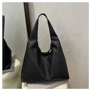 Close-up of black pebble leather texture on minimalist large capacity hobo tote bag