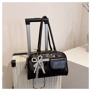 Detail of dark brown vintage tote bag with front flap pockets and pearl bow charm