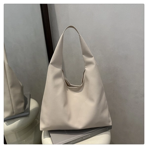 Close-up of creamy white tote bag with premium litchi grain texture and minimal design