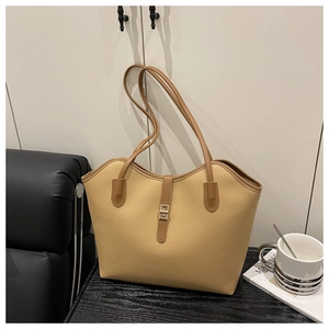 Detail of light brown lychee grain leather tote bag with metal buckle and long straps