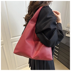 Side view of red large capacity tote bag with lychee texture leather on shoulder