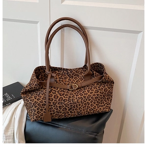 Detail of leopard print tote bag with brown leather handles and buckle decoration