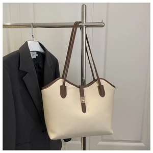 Detail of cream and brown tote bag featuring lychee grain leather and golden twist lock