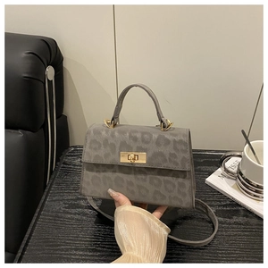 Detailansicht der grauen Handtasche mit Leopardenmuster und goldenem Drehverschluss