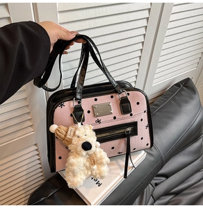 Detail showing pink polka dot handbag with bow patterns and a cute teddy bear charm