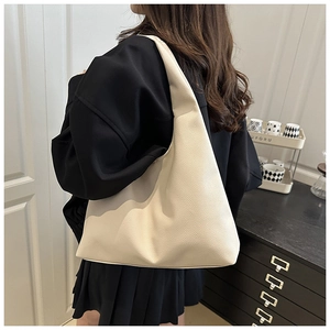 Side view of large cream tote bag showing soft lychee texture and slouchy hobo silhouette