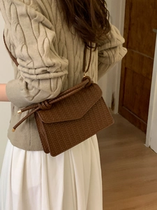 Deep brown woven leather crossbody bag with knot shoulder strap and gold metallic accents
