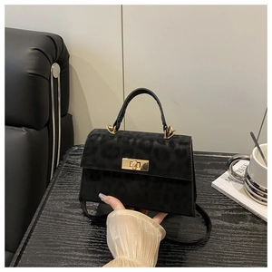 Detail der schwarzen Handtasche mit Leopardenmuster, goldener Schließe und Matt-Effekt