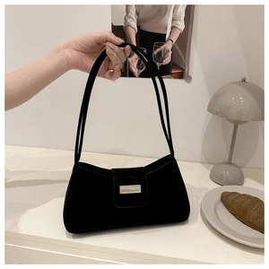 Détail du sac baguette en velours noir élégant avec une boucle rectangulaire dorée chic