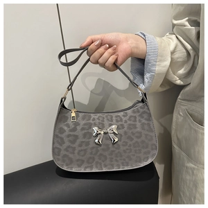 Détail du sac à bandoulière léopard gris avec nœud métallique argenté et fermeture éclair