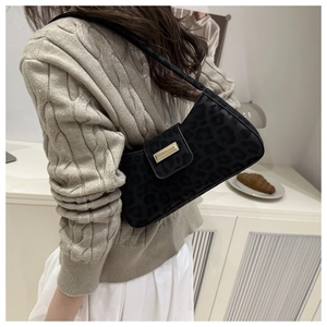 Détail du sac sous le bras à motif léopard avec boucle dorée sur la bandoulière