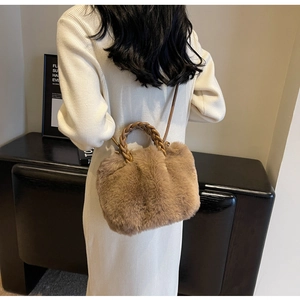 Detail of plush brown faux fur handbag with leather woven handle and crossbody strap