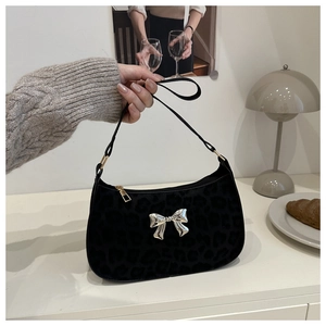 Détail du sac sous l'aisselle imprimé léopard noir avec noeud argenté et zip doré