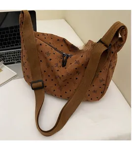 Detail of adjustable wide shoulder strap on brown corduroy crossbody bag with heart prints