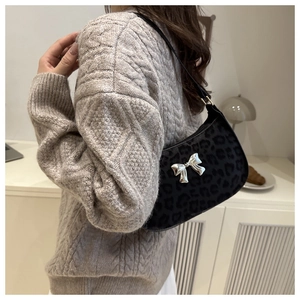 Détail du sac sous le bras à motif léopard noir avec un nœud argenté élégant