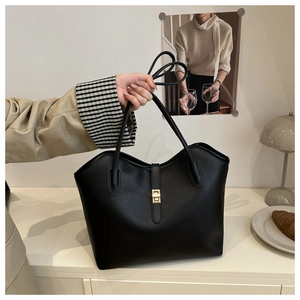 Detail of black pebbled leather tote bag featuring elegant golden twist lock hardware