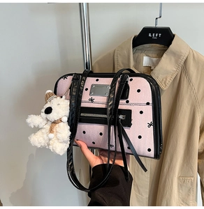 Detailed close-up of pink polka dot shoulder bag with cute white plush bear charm