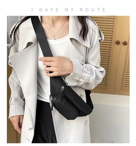Close-up of black oxford cloth chest bag with multi-zipper compartments and wide strap