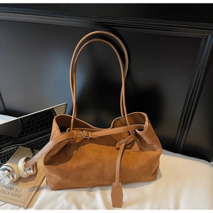Brown frosted leather tote bag with office essentials like laptop and headphones