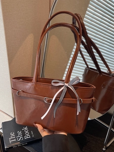 Borsa tote marrone lucida da donna con nastro decorativo e anelli metallici