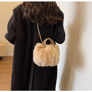 Sac nuage en fausse fourrure kaki avec poignée tressée porté à l'épaule par un mannequin