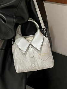 Sac à main argenté style chemise avec col et boutons sur fond de cuir foncé élégant