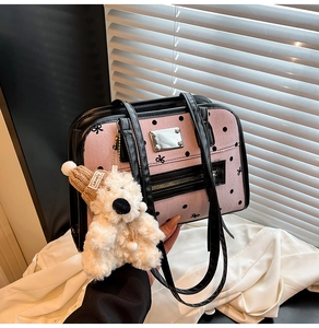 Detail of pink polka dot tote bag with black trim and cute plush bear keychain charm