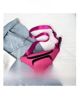 Detail of vibrant pink nylon waist bag with double black zippers and adjustable strap