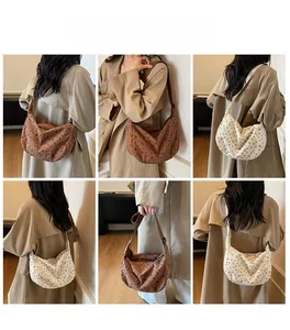Detail view of corduroy hobo bag featuring delicate bow prints and adjustable wide strap
