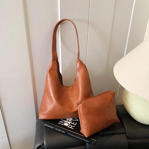 Vintage tan brown faux leather tote and matching small pouch set in warm lighting