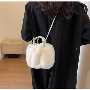 Detail of soft off-white faux fur bucket bag with woven PU handle and long shoulder strap