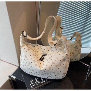 Detailed shot of white corduroy crossbody bag with heart prints and double zippers