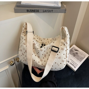 Detailed view of corduroy hobo bag with bow and heart prints and adjustable strap