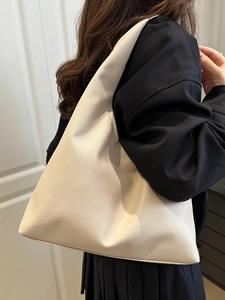 Large beige leather hobo tote bag with lychee texture worn by model for daily commute