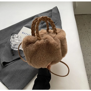 Détail du sac à main en fausse fourrure marron avec poignée en cuir tressé et bandoulière