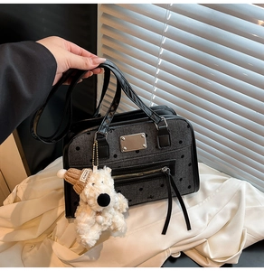 Detail of grey polka dot denim tote bag with plush bear charm and metallic hardware