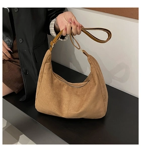 Close-up of warm brown matte suede hobo bag with adjustable leather shoulder strap and zipper