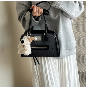 Close-up of black retro tote bag with silver square hardware and cute puppy charm