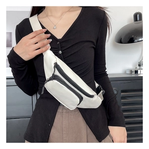 Detail view of multi-compartment white waterproof chest bag with black zipper accents