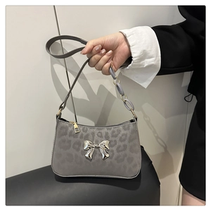 Close-up of grey leopard print handbag featuring a silver butterfly bow and resin chain