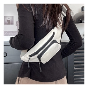 Back view of a model wearing a white waterproof nylon crossbody chest bag with black straps