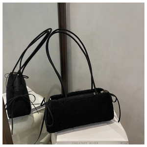Detail of black lamb wool baguette bag featuring plush texture and bow drawstrings