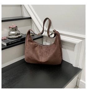 Detail of dark brown matte suede hobo bag with adjustable leather strap and zipper