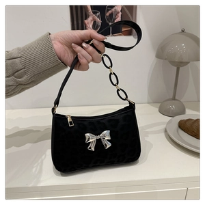 Detail of black velvet leopard print shoulder bag with silver 3D butterfly buckle