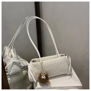 Detail of white plush faux fur shoulder bag with leather straps and monster charm