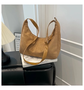 Detail of a brown matte suede hobo bag with a smooth adjustable leather shoulder strap
